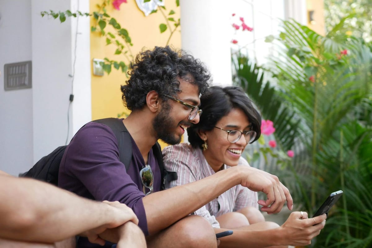 Two friends smiling at a phone together